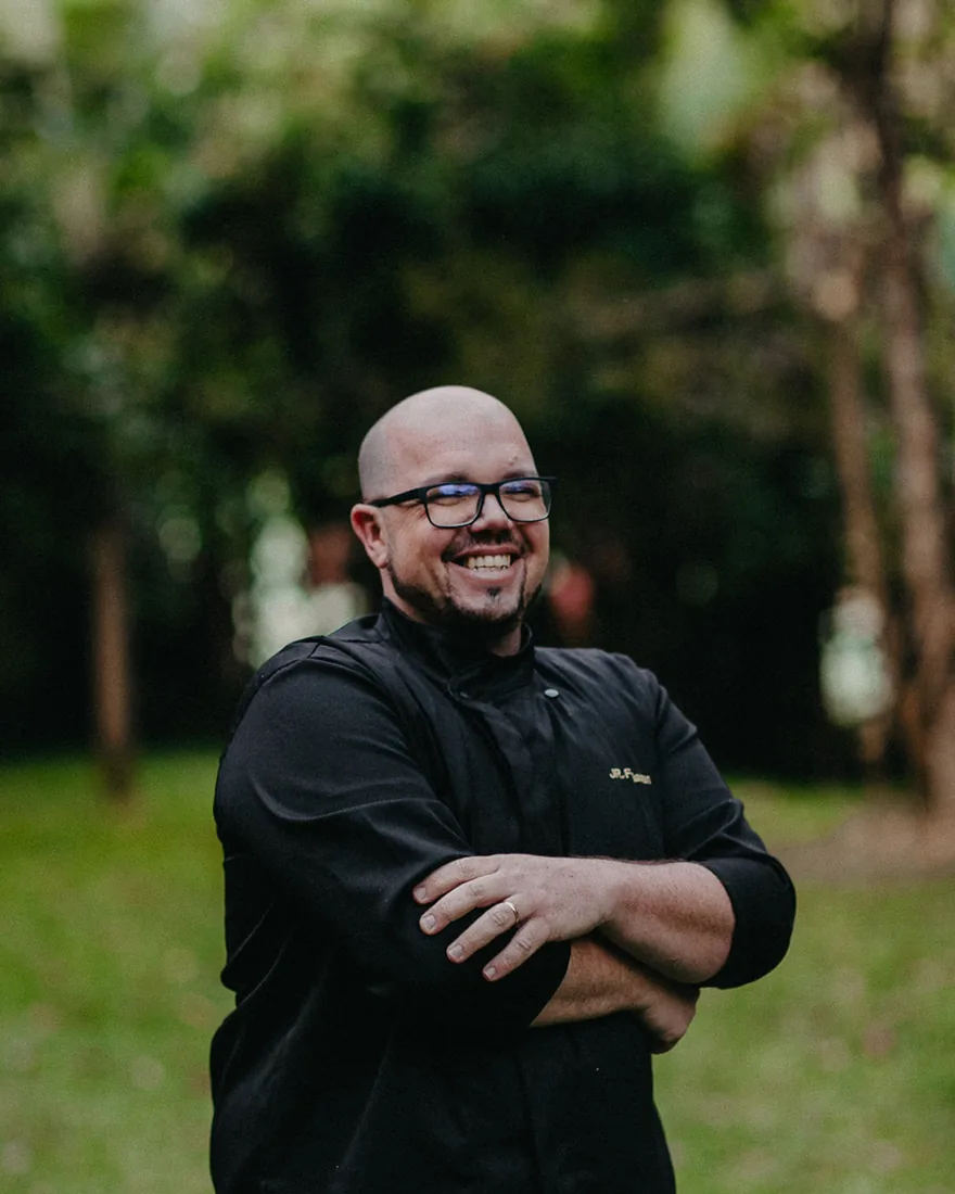 Jr. Feldman, chef e fundador da Coffice, sorrindo de braços cruzados, com dólmã preta